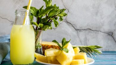 Bright yellow tropical smoothie in a glass with a straw